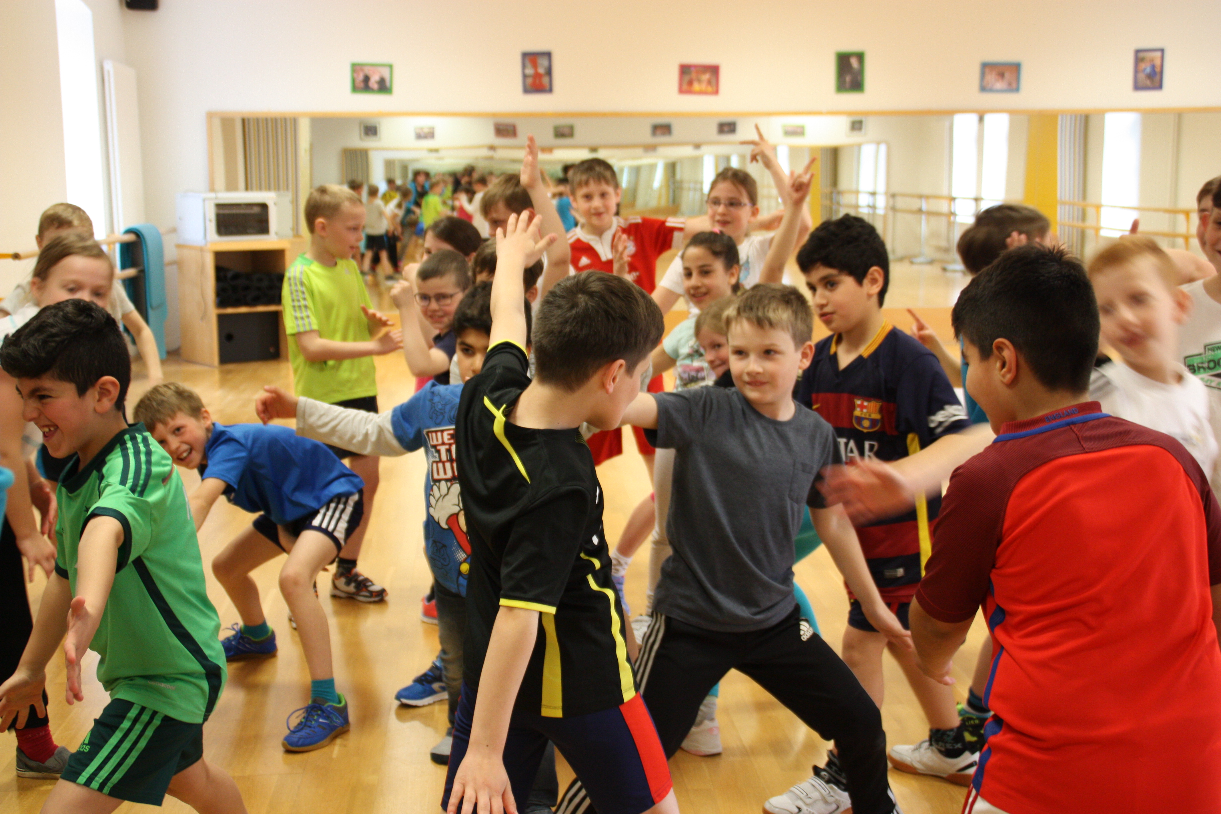 Eine Gruppe von etwa 20 Kindern führt in Sportbekleidung ein Spiel durch.